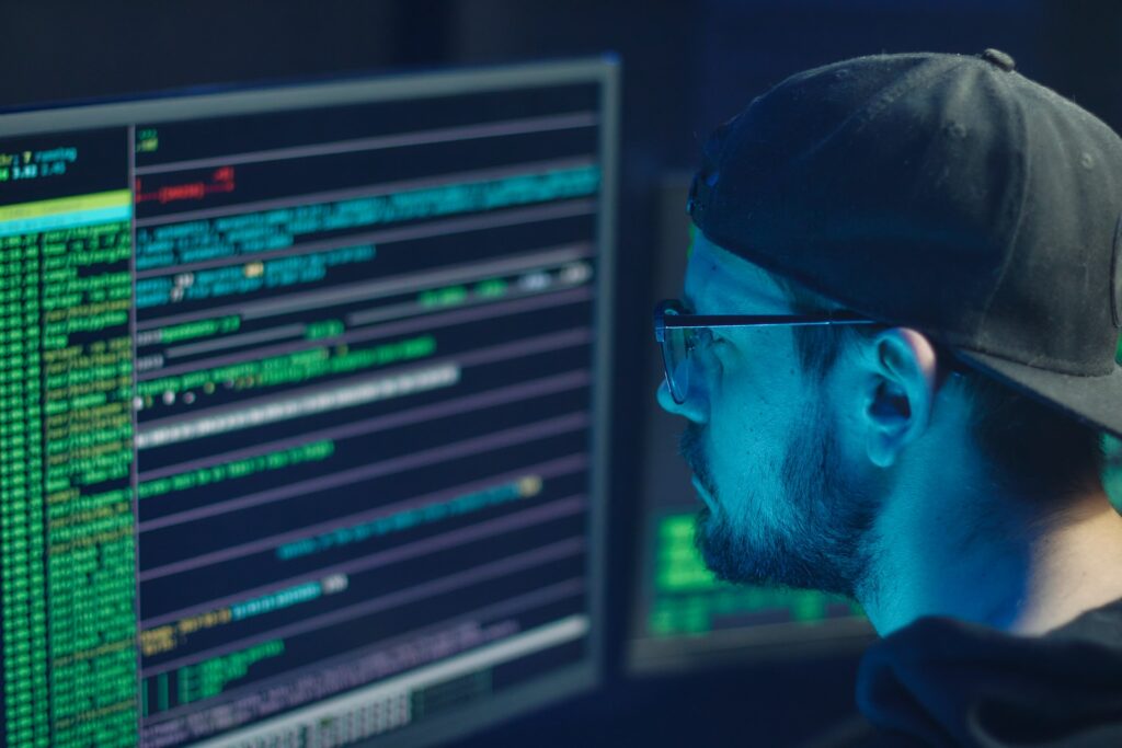 cybercrime photo of a man looking at a screen full of code.